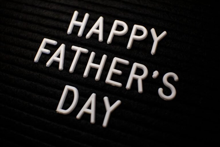 Close-up of 'Happy Father's Day' text in white letters on a black textured background.